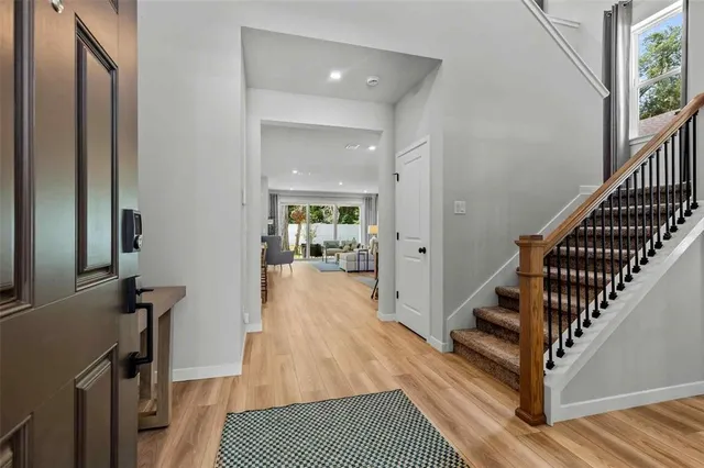 a view of a hallway with wooden floor and staircase