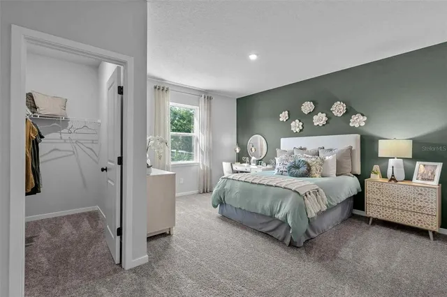 a bedroom with a bed and a painting on the wall