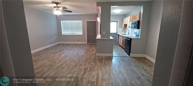 a view of a room with wooden floor and a window