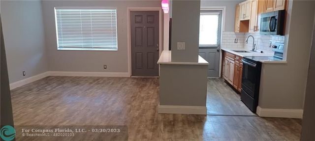 a kitchen with granite countertop a sink and a stove top oven