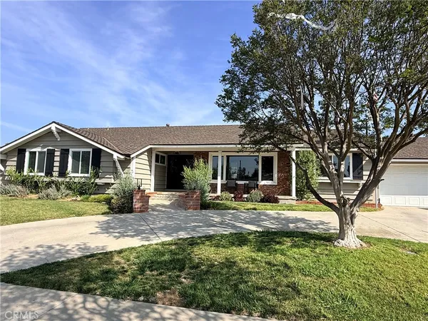a front view of a house with garden yard and sitting area
