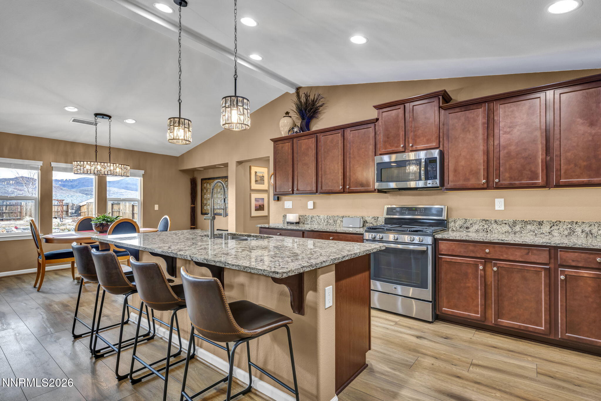 148 Snake Road Dayton, NV 89403 - Photo 15 of 57 a kitchen with stainless steel appliances granite countertop wooden cabinets a stove a sink and a wooden floors