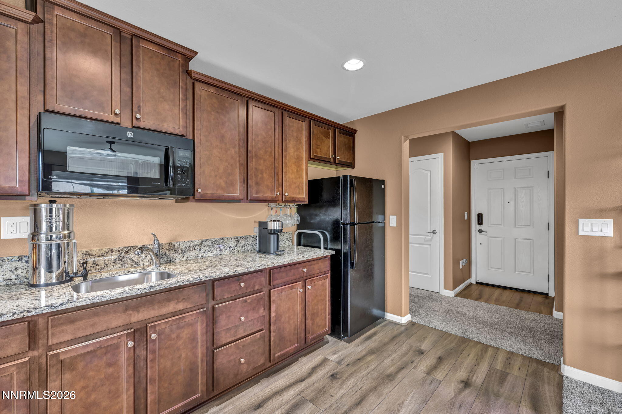 148 Snake Road Dayton, NV 89403 - Photo 33 of 57 a kitchen with stainless steel appliances granite countertop a refrigerator a sink dishwasher and wooden cabinets with wooden floor