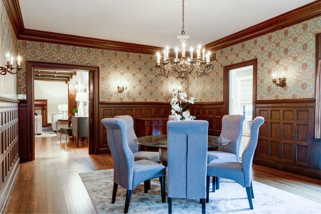 a view of a dining room with furniture a chandelier and wooden floor