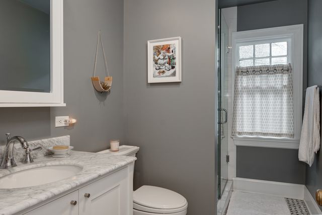 a bathroom with a granite countertop sink mirror vanity and toilet