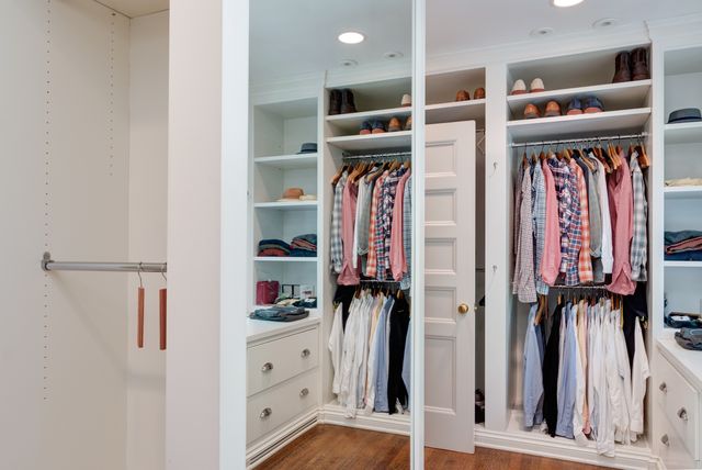 a view of walk in closet with clothes and shoes