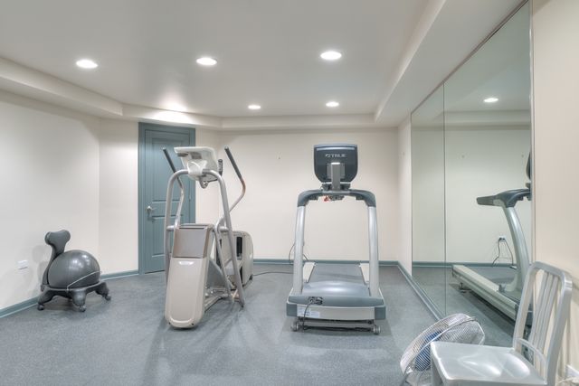 a room with gym equipment and a chandelier