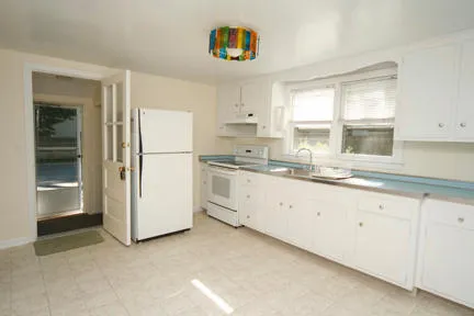 a kitchen with granite countertop white cabinets and white appliances