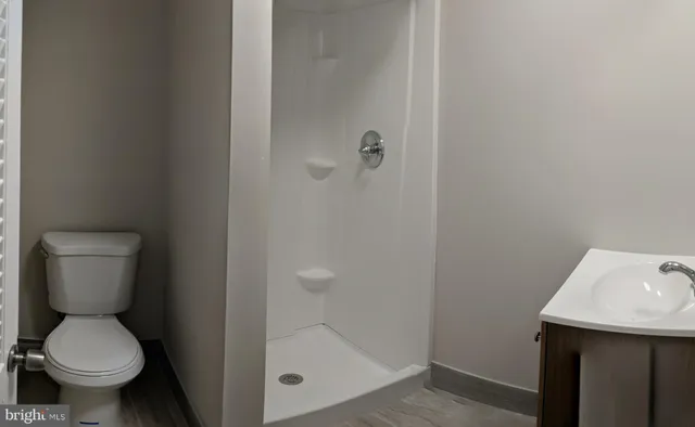 an empty room with wooden floor and a hallway