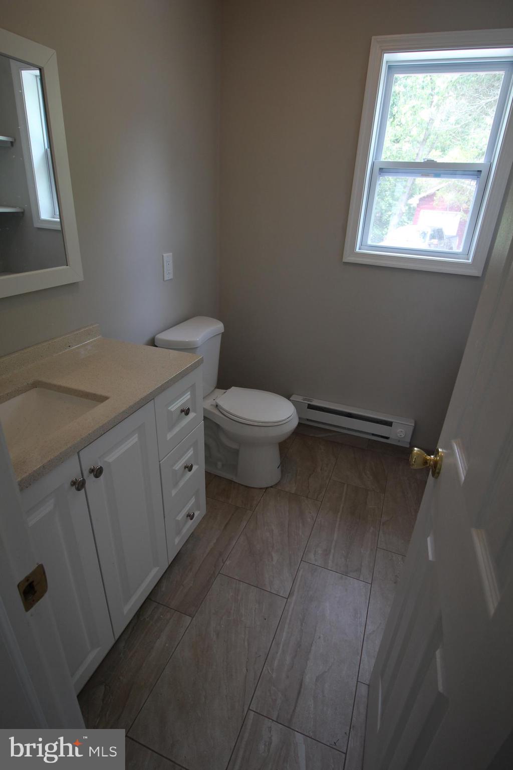 424 Trenton Road Browns Mills, NJ 08015 - Photo 25 of 109 a bathroom with a granite countertop toilet a sink and a window