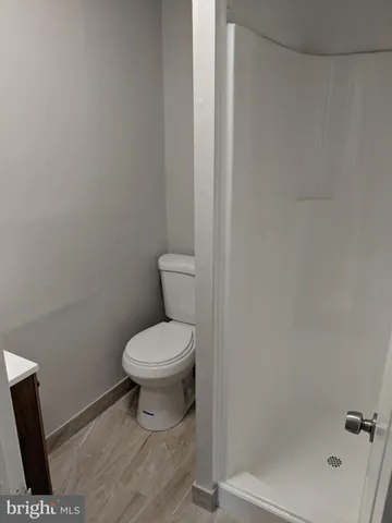 a bathroom with a granite countertop toilet a sink and a window