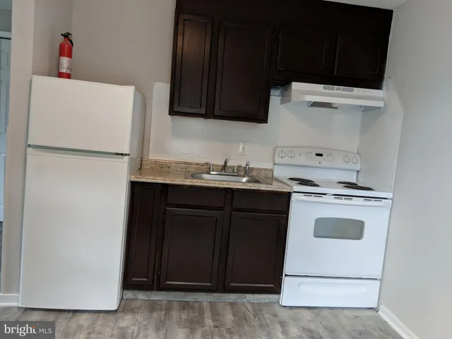 a utility room with wooden floor washer and dryer