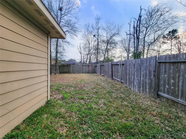 a view of backyard with wooden fence