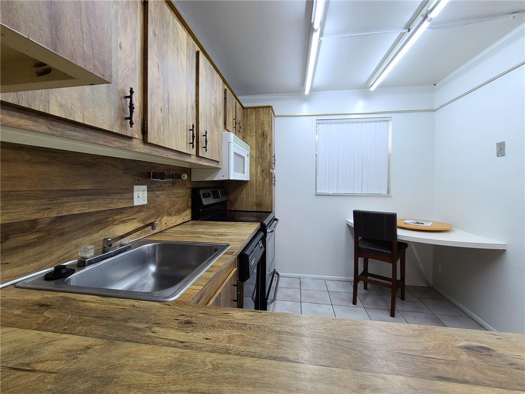 8301 Sands Point Boulevard, Unit 306S Tamarac, FL 33321 - Photo 12 of 13 a kitchen with a sink cabinets and wooden floor