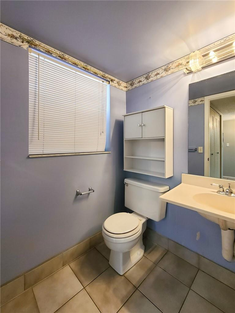 8301 Sands Point Boulevard, Unit 306S Tamarac, FL 33321 - Photo 13 of 13 a bathroom with a granite countertop sink mirror vanity and toilet