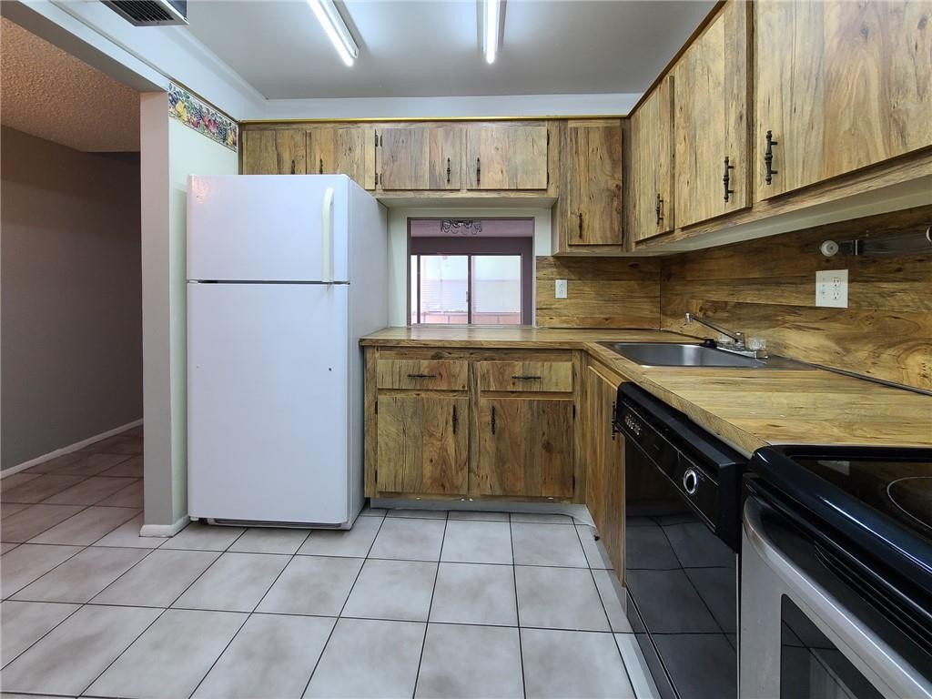8301 Sands Point Boulevard, Unit 306S Tamarac, FL 33321 - Photo 2 of 13 a kitchen with a stove a refrigerator and a sink