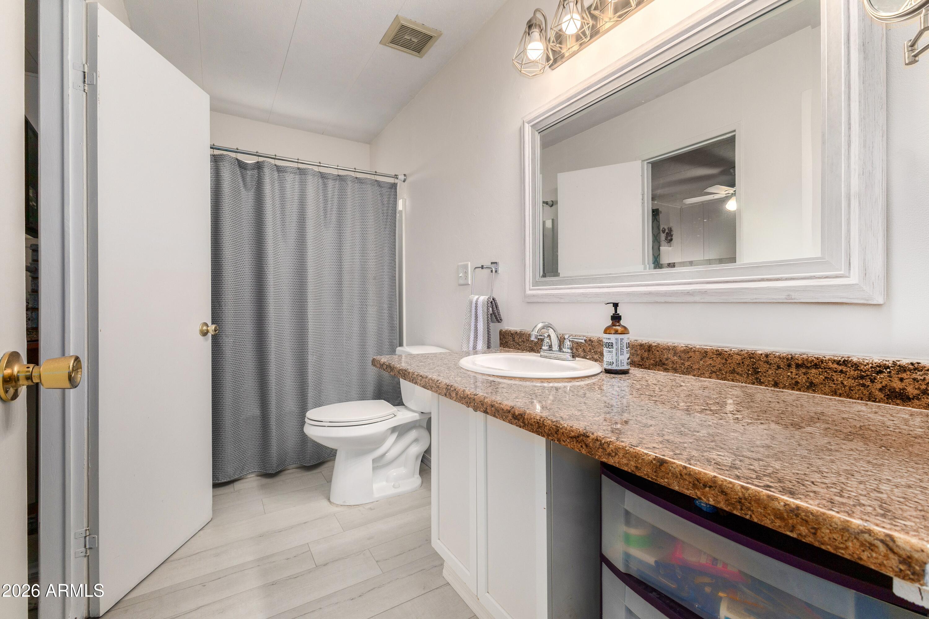 758 South 87th Way Mesa, AZ 85208 - Photo 15 of 24 a bathroom with a granite countertop sink and a toilet