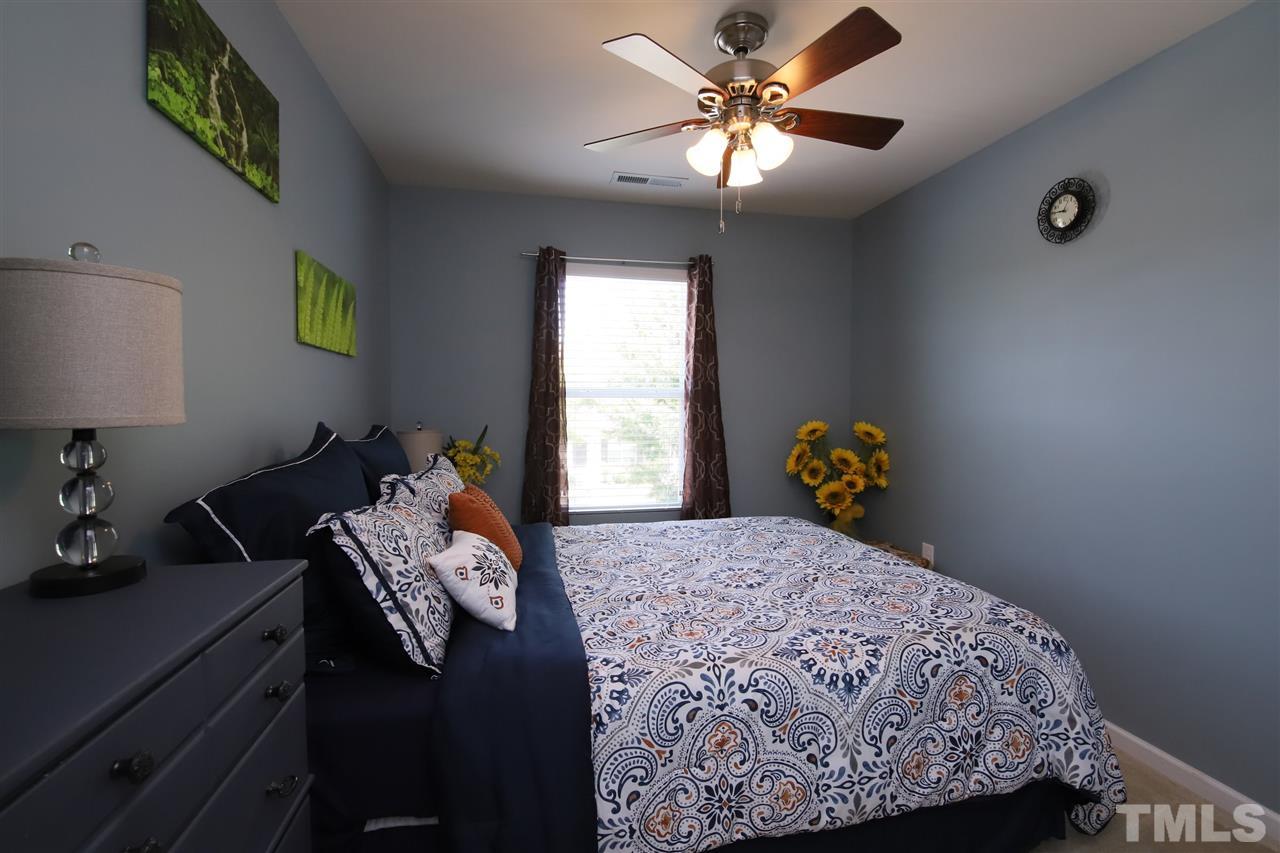 2917 Berkeley Springs Place Raleigh, NC 27616 - Photo 22 of 30 a bedroom with a bed and a lamp on dresser