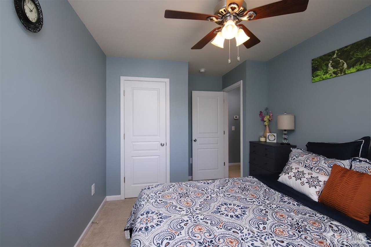 2917 Berkeley Springs Place Raleigh, NC 27616 - Photo 23 of 30 a bedroom with a bed and a chandelier