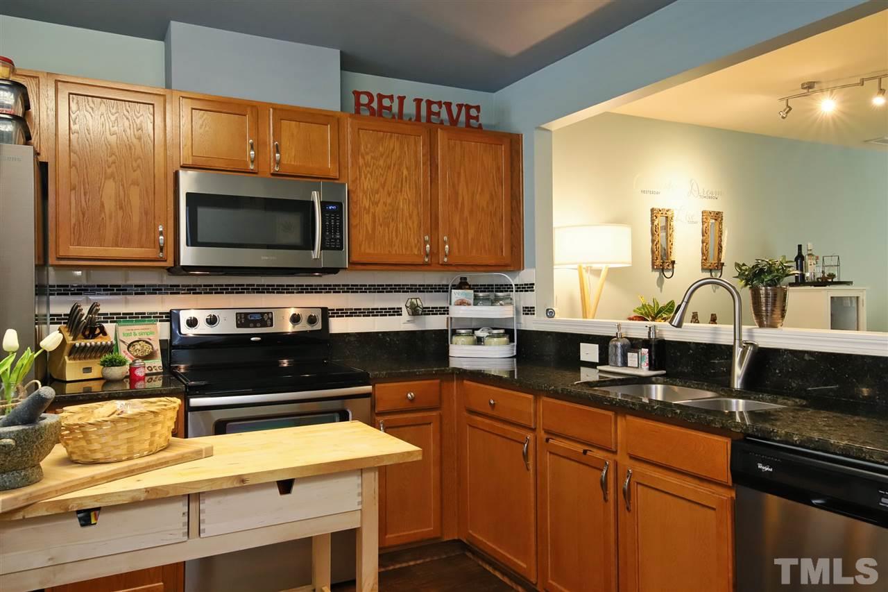 2917 Berkeley Springs Place Raleigh, NC 27616 - Photo 6 of 30 a kitchen with granite countertop a stove and a microwave