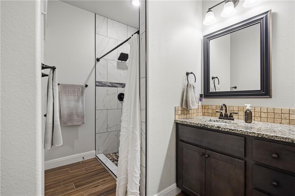 1570 Maryville Loop Beeville, TX 78102 - Photo 14 of 19 a bathroom with a granite countertop sink vanity mirror next to a window