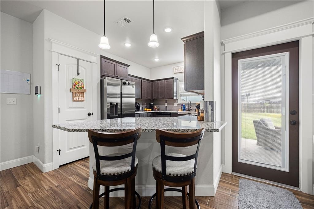 1570 Maryville Loop Beeville, TX 78102 - Photo 6 of 19 a dining room with stainless steel appliances kitchen island granite countertop a table chairs and a refrigerator