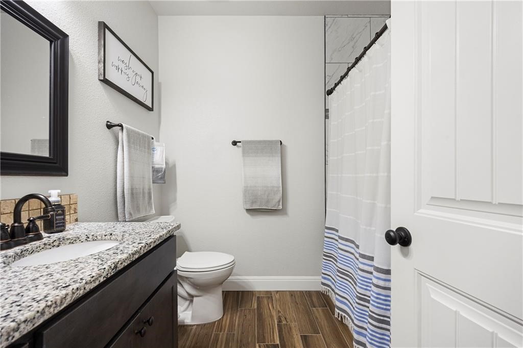 1570 Maryville Loop Beeville, TX 78102 - Photo 9 of 19 a bathroom with a granite countertop sink toilet a mirror and shower