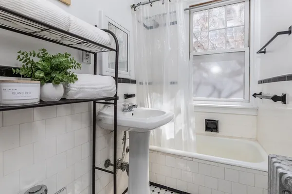 a bathroom with a sink and mirror with bathtub