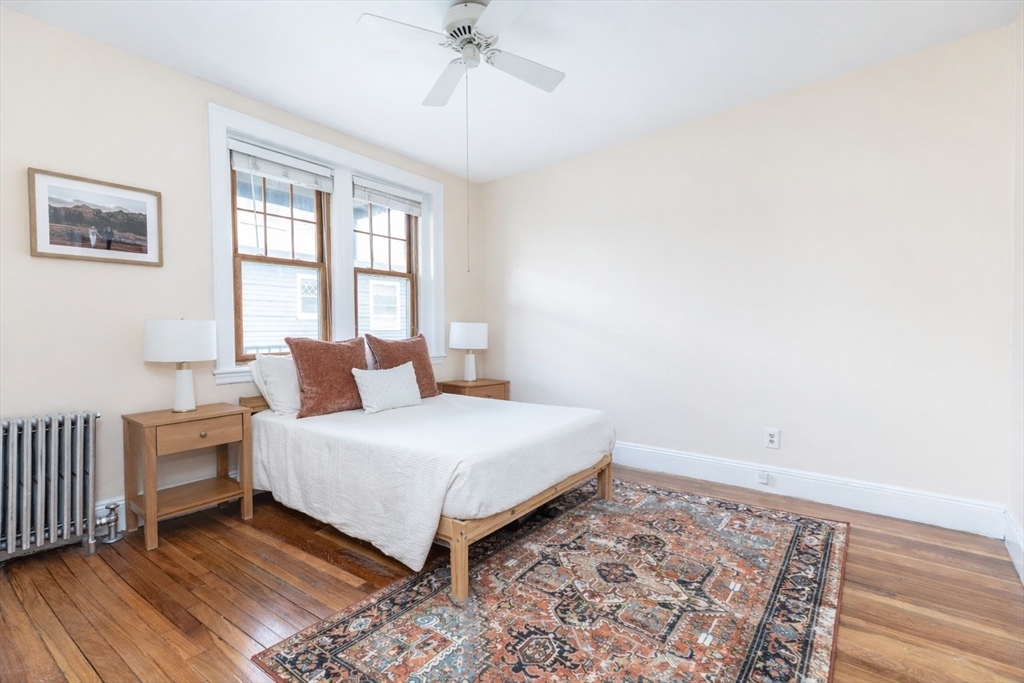 48 Strathmore Road, Unit 26 Boston, MA 02135 - Photo 10 of 15 a bedroom with a bed and wooden floor