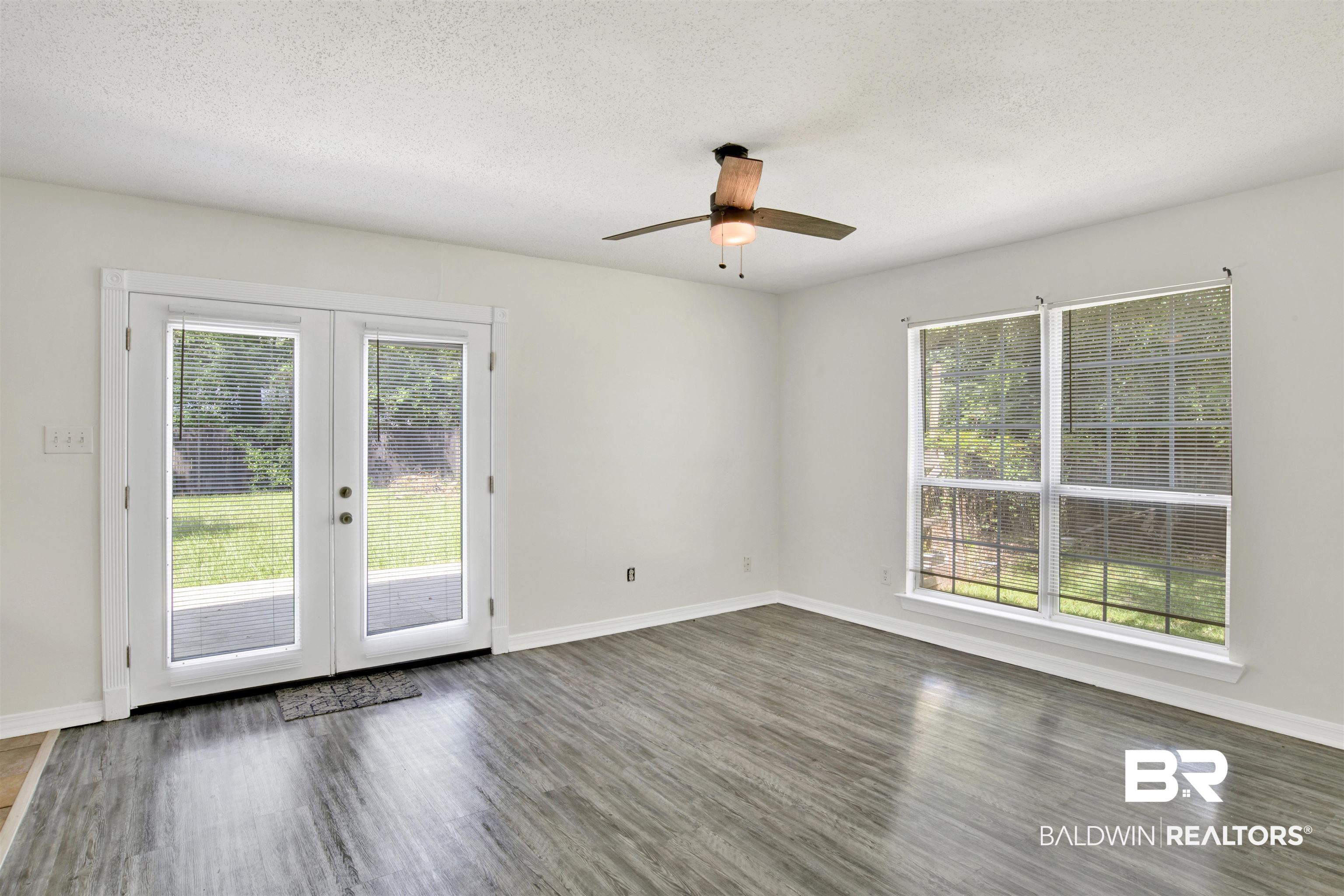 5480 Country Club Boulevard Theodore, AL 36582 - Photo 5 of 36 Spare room featuring a textured ceiling, dark hardwood / wood-style flooring, ceiling fan, and french doors