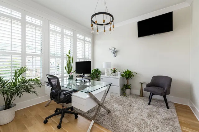 a living room with furniture a flat screen tv and a large window