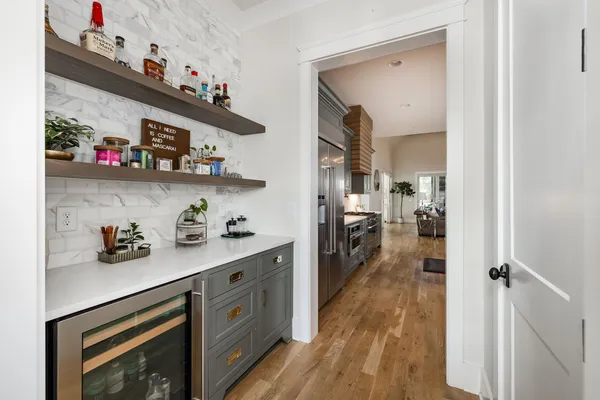 a large kitchen with stainless steel appliances a stove center island a oven a dining table and chairs with wooden floor