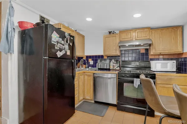 a kitchen with stainless steel appliances granite countertop a refrigerator sink and stove