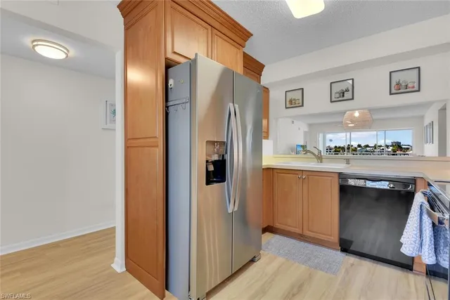 a kitchen with stainless steel appliances a refrigerator and wooden floor