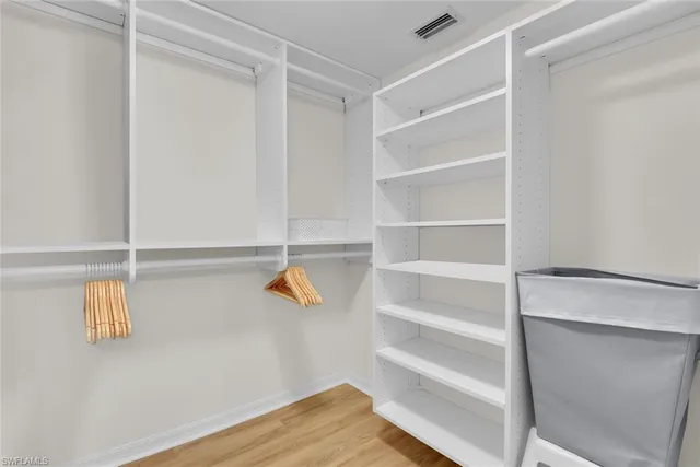 a view of walk in closet with empty racks