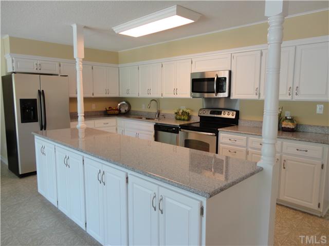 8804 Katharina Court Raleigh, NC 27613 - Photo 4 of 22 a kitchen with stainless steel appliances granite countertop a sink a stove top oven a counter space and cabinets