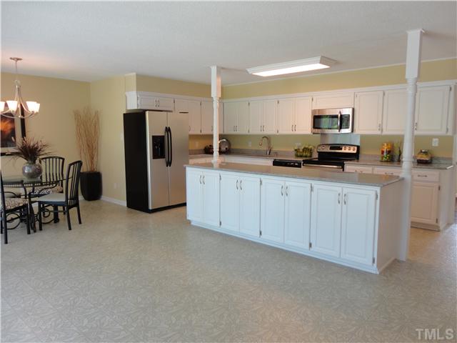 8804 Katharina Court Raleigh, NC 27613 - Photo 5 of 22 a kitchen with white cabinets and refrigerator