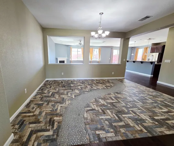 a view of a livingroom with a furniture wooden floor and chandelier