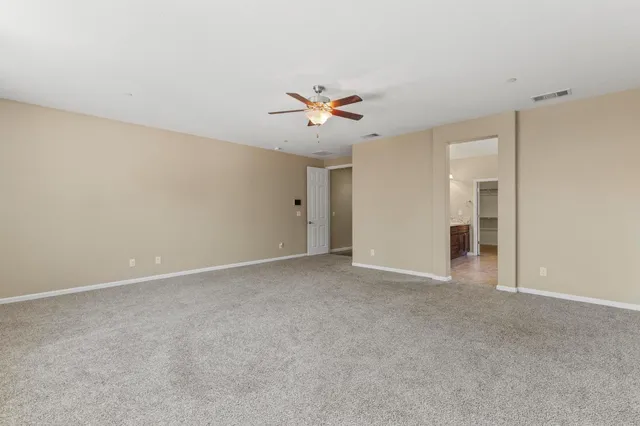 a view of an empty room with a ceiling fan