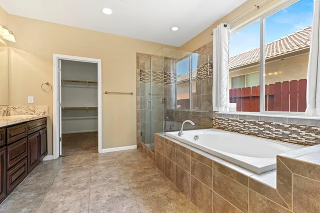 a spacious bathroom with a tub sink shower and mirror