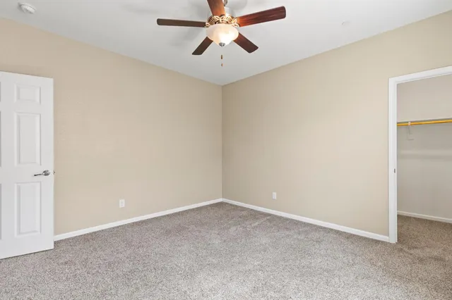 an empty room with chandelier fan