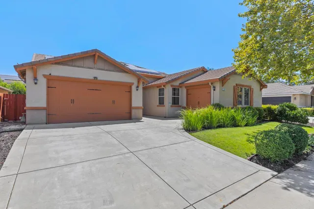 a view of a house with a yard and potted plants