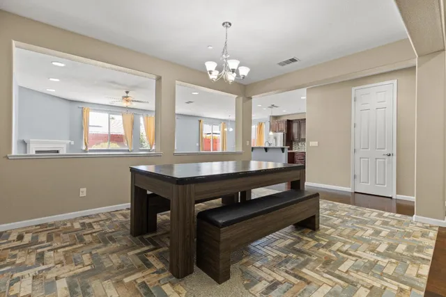 a room with chandelier and wooden floor