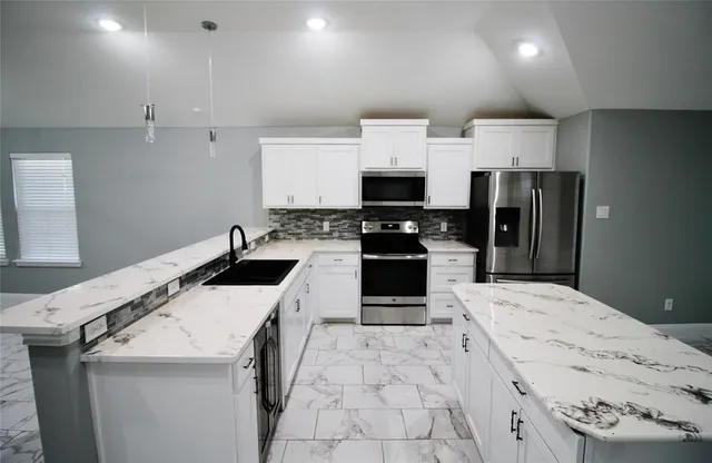 a kitchen with a sink a stove top oven and refrigerator
