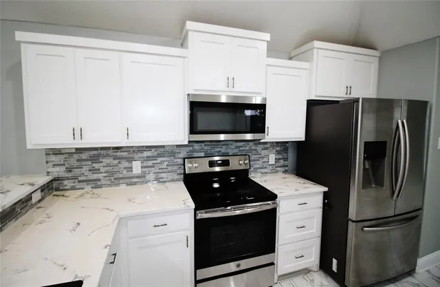 a kitchen with stainless steel appliances a refrigerator stove and microwave