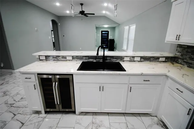 a kitchen with a sink dishwasher and a stove with wooden floor