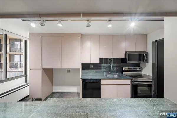 a kitchen with stainless steel appliances granite countertop a stove and a refrigerator