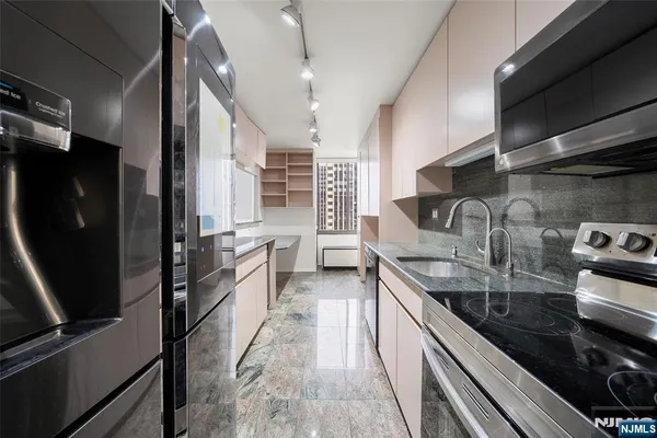 a kitchen with stainless steel appliances granite countertop a sink and a stove
