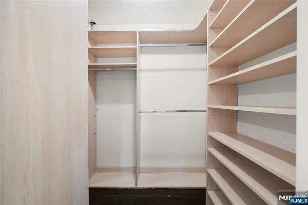 a view of walk in closet with empty racks