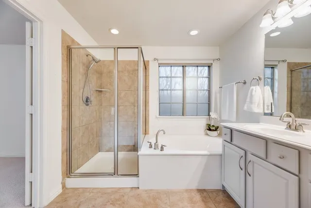 a bathroom with a tub sink shower and mirror